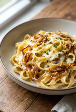 A serving of creamy caramelized onion pasta in a rustic bowl.