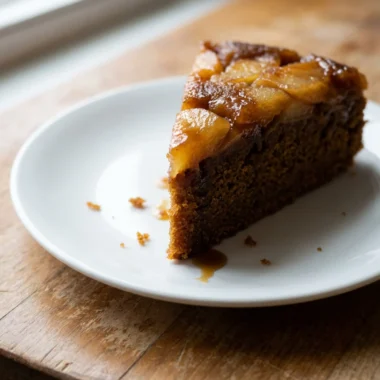 Close-up shot of a slice of gingerbread apple cake with a fork taking a bite.