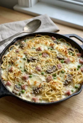 A close-up of a forkful of creamy ham tetrazzini pasta.