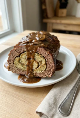 A finished slice of meatloaf with a stuffing swirl in the center.